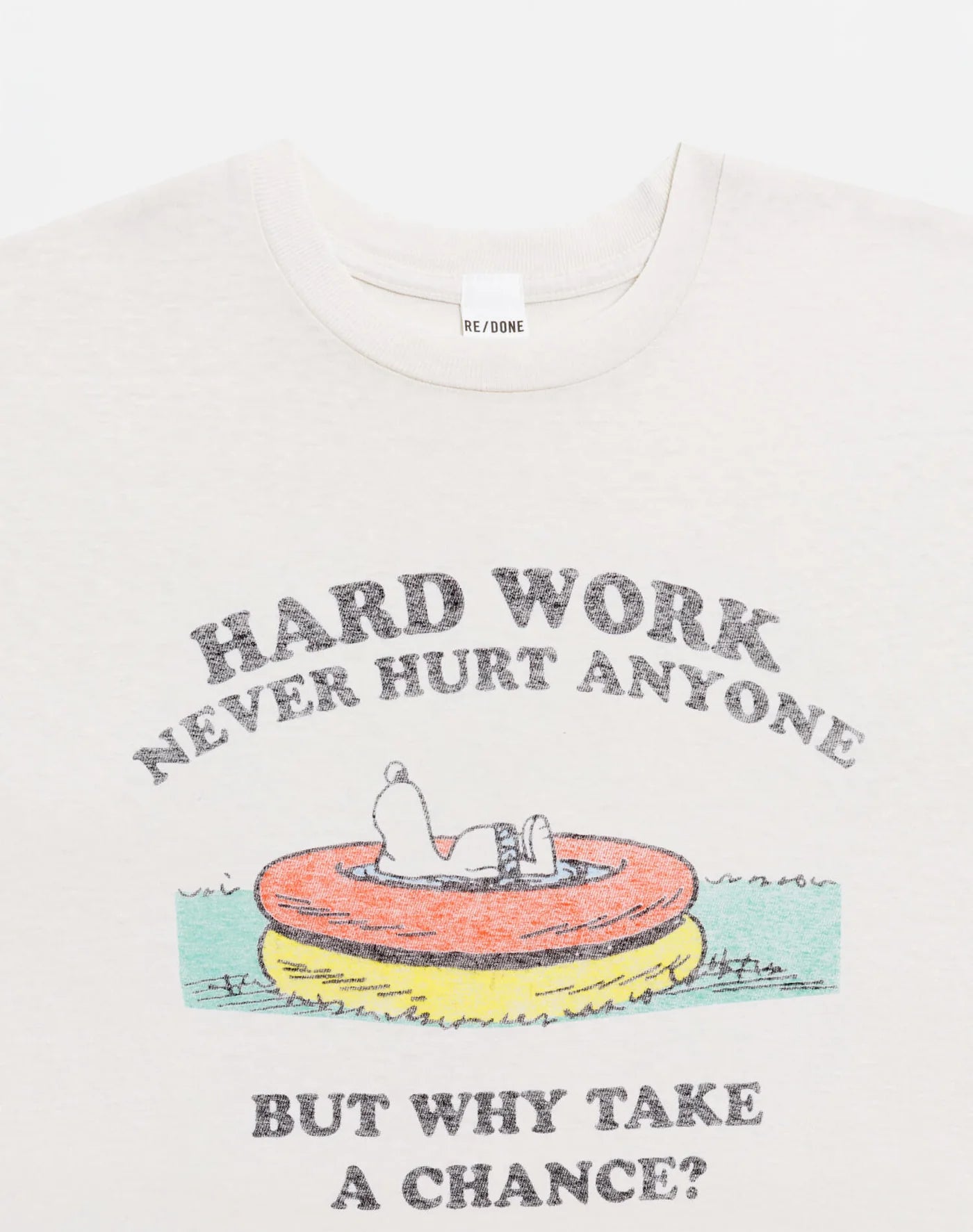 The RE/DONE Hard Work Snoopy Tee is a white recycled cotton t-shirt with Snoopy on a pool float. "HARD WORK NEVER HURT ANYONE" appears above, and "BUT WHY TAKE A CHANCE?" below. Perfect for vintage Peanuts fans.
