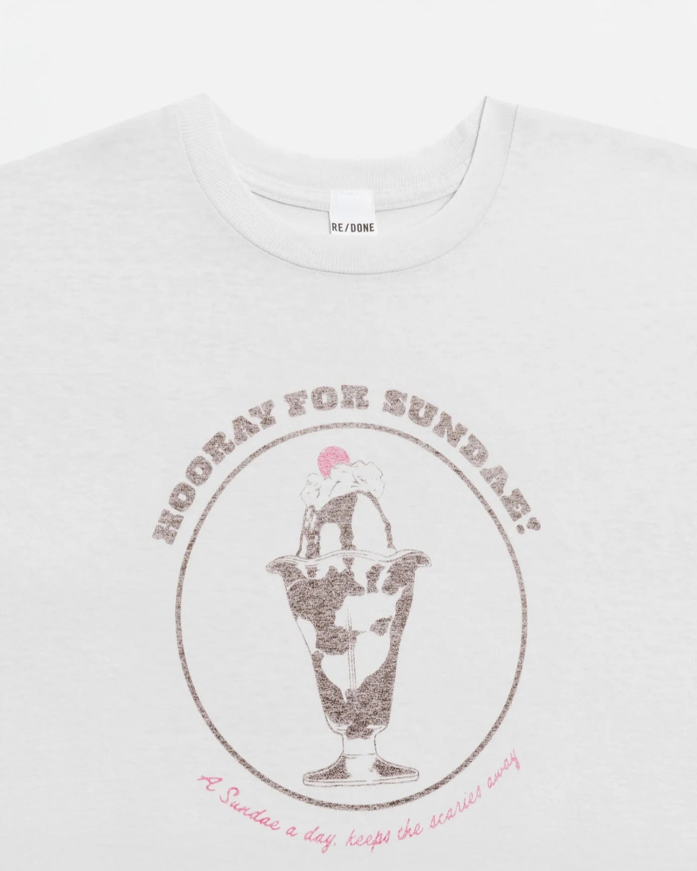 The Sundae Tee by RE/DONE is a white vintage-style t-shirt featuring an ice cream sundae with "HOORAY FOR SUNDAY!" above and "A Sundae a day keeps the scaries away." below, made from soft recycled cotton.