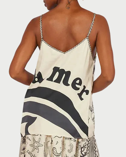 Woman wearing a camisole with text and patterns against a desert landscape