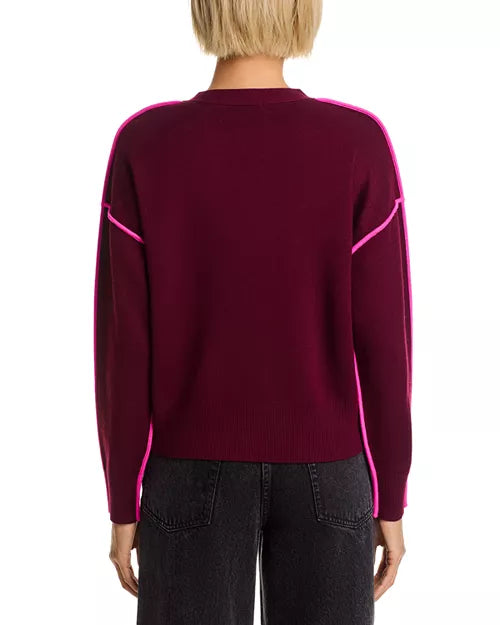 Maroon sweater with pink accents worn by a person on a white background