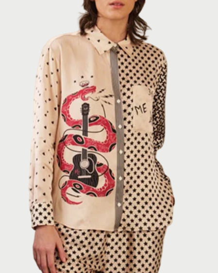 A person wears the ME369 Scarlett Shirt, a cream and black mixed-print button-down with a red snake-wrapped guitar graphic and black star patterns, paired with matching star-patterned pants.