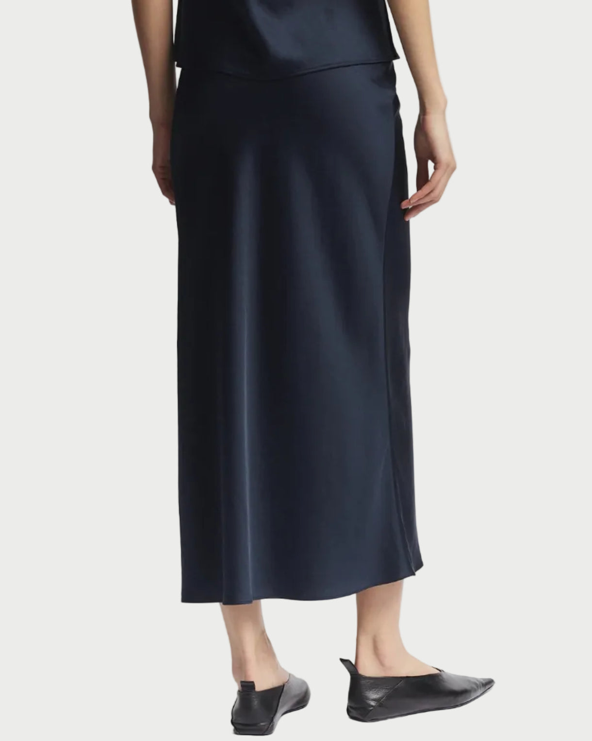 Person wearing a black slip dress on a white background