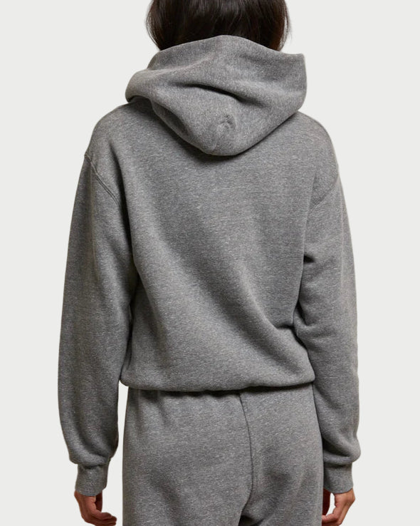 Person wearing a gray hoodie and pants against a plain background