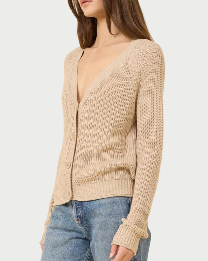 A woman models the One Grey Day Raleigh Cardigan, a relaxed fit, chunky fisherman-rib knit button-up with long sleeves, paired with blue jeans against a plain light background.