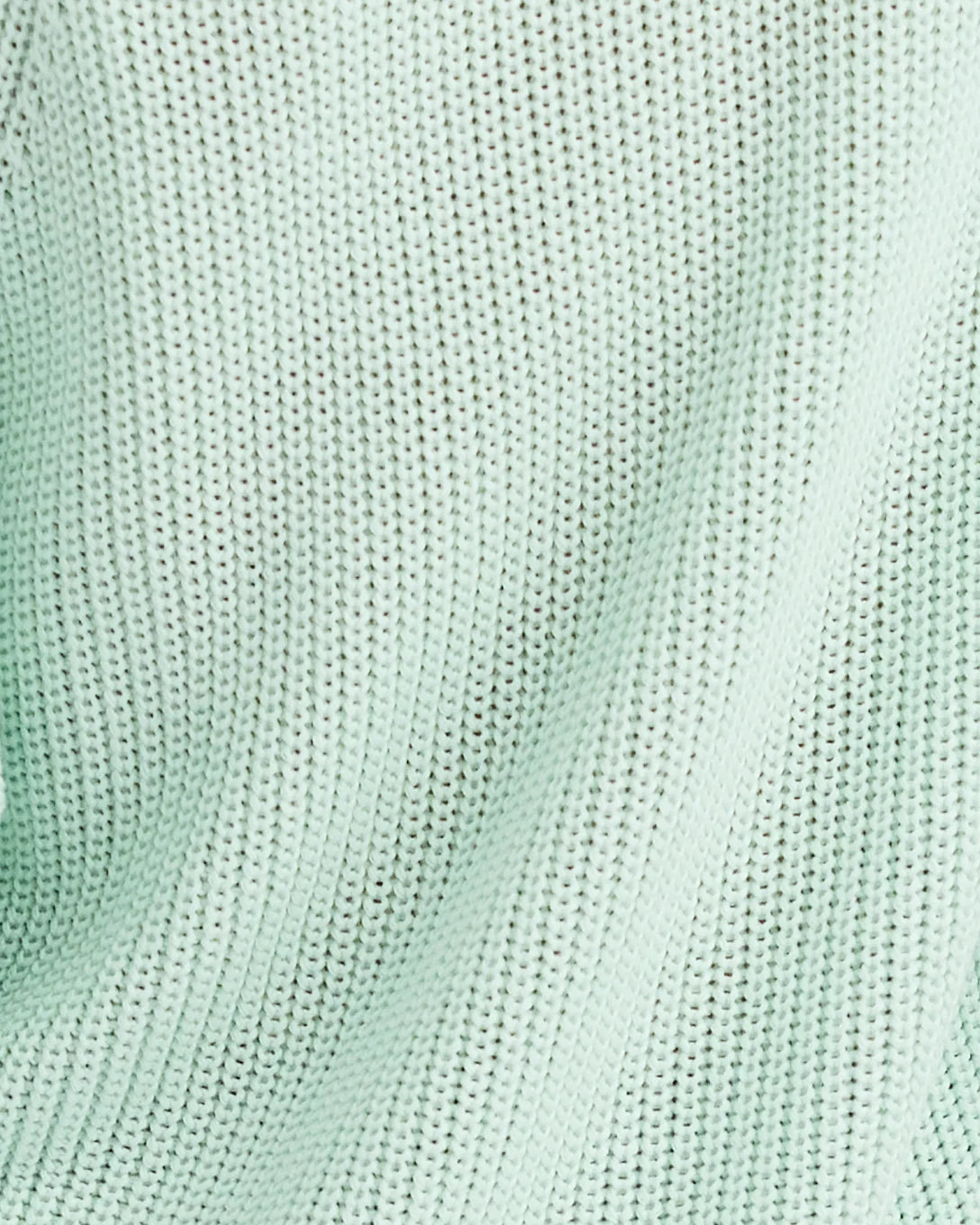 Close-up of a textured light green fabric surface