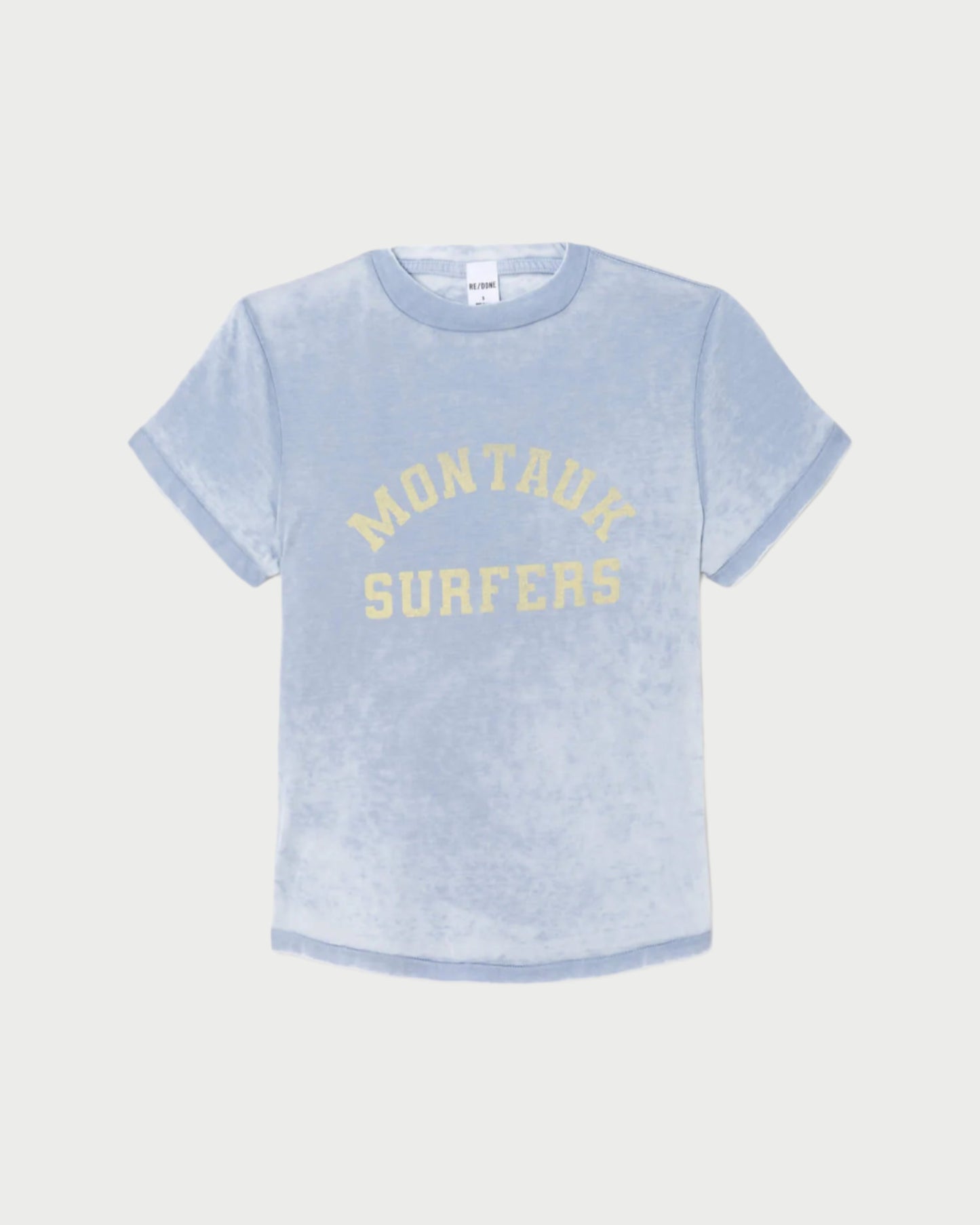 The RE/DONE Montauk Tee is a light blue, short-sleeve vintage-inspired shirt with rolled cuffs and "MONTAUK SURFERS" in yellow on the front, crafted from soft organic cotton for a casual look.