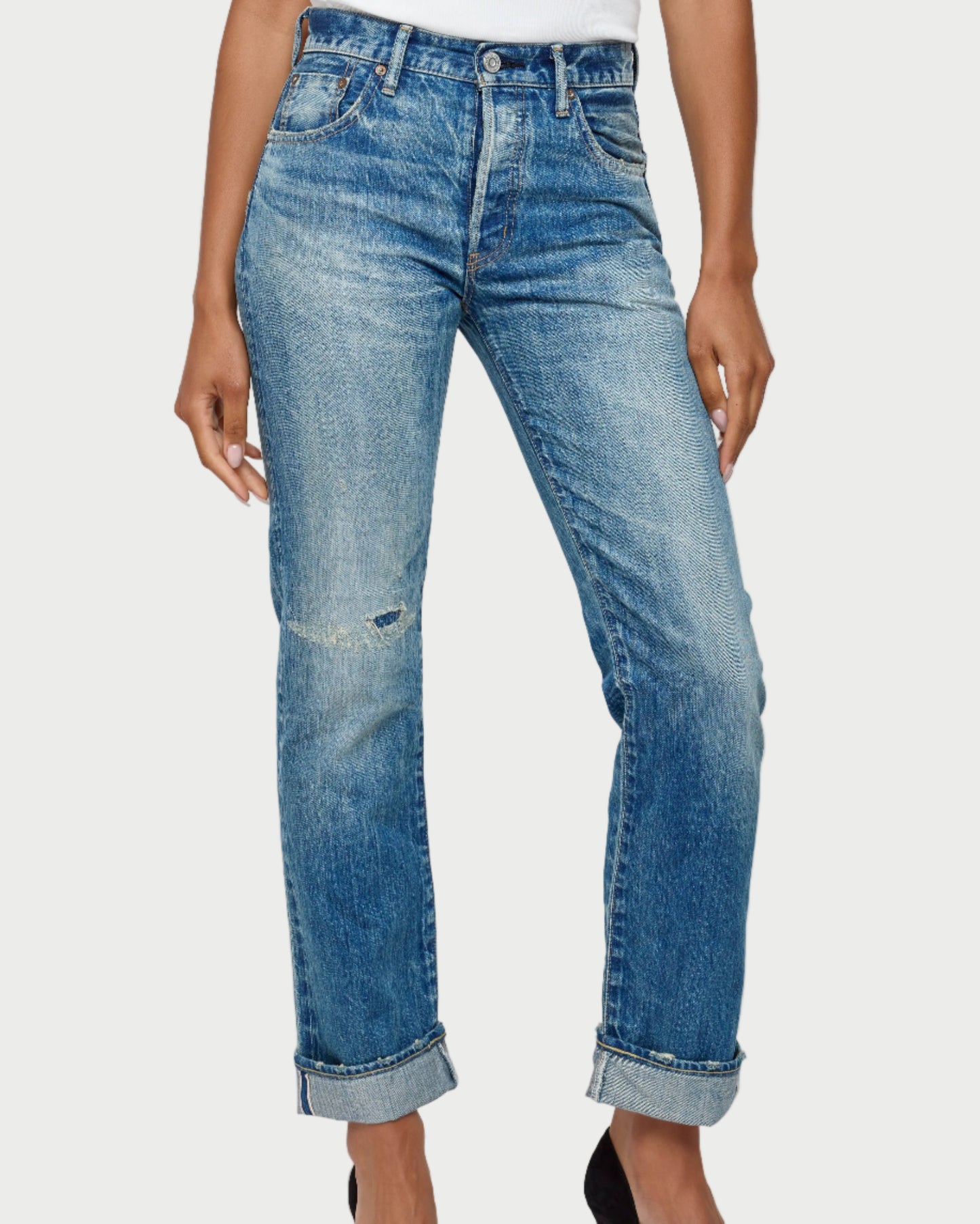 Blue jeans worn by a person on a white background