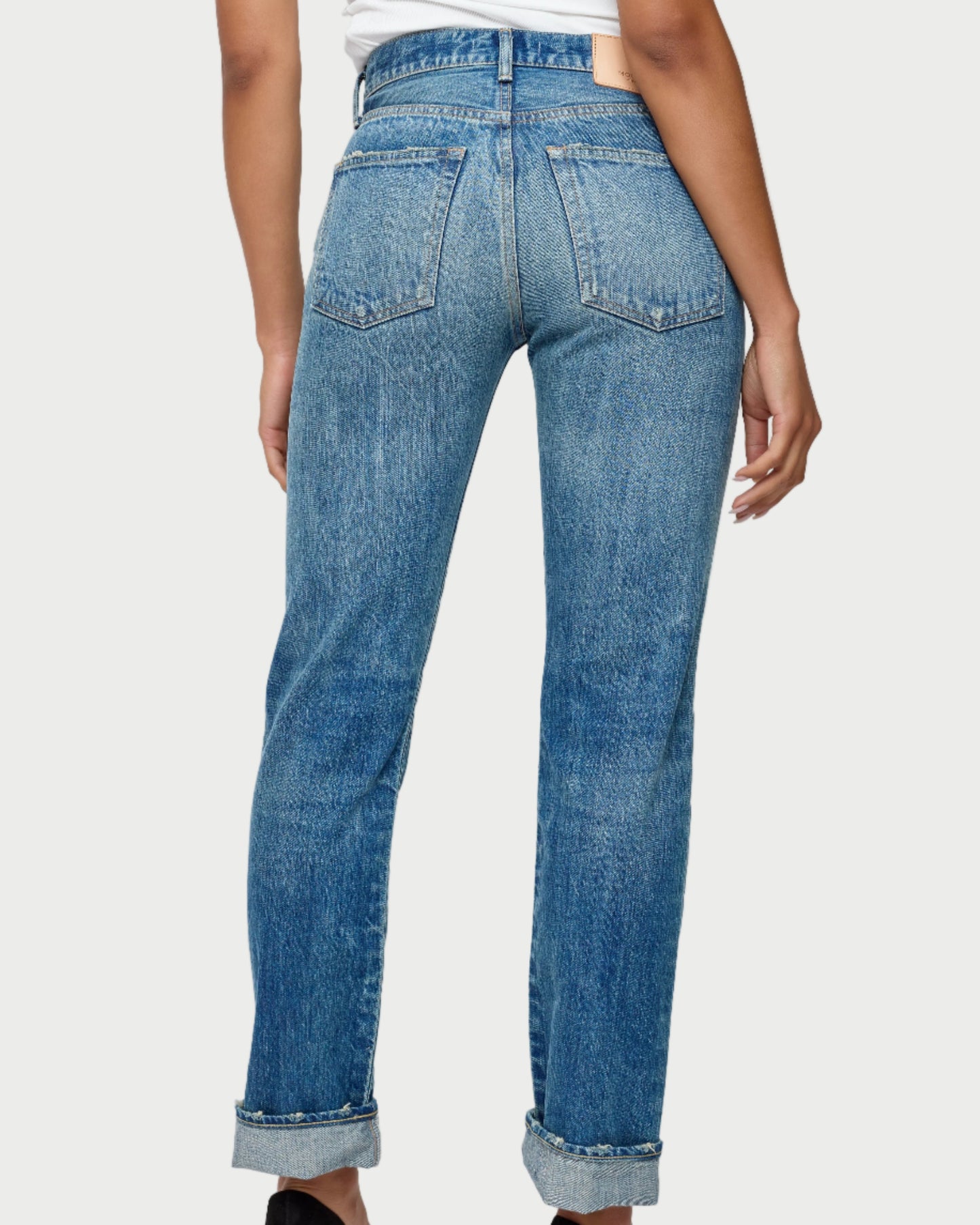 Blue jeans worn by a person on a white background