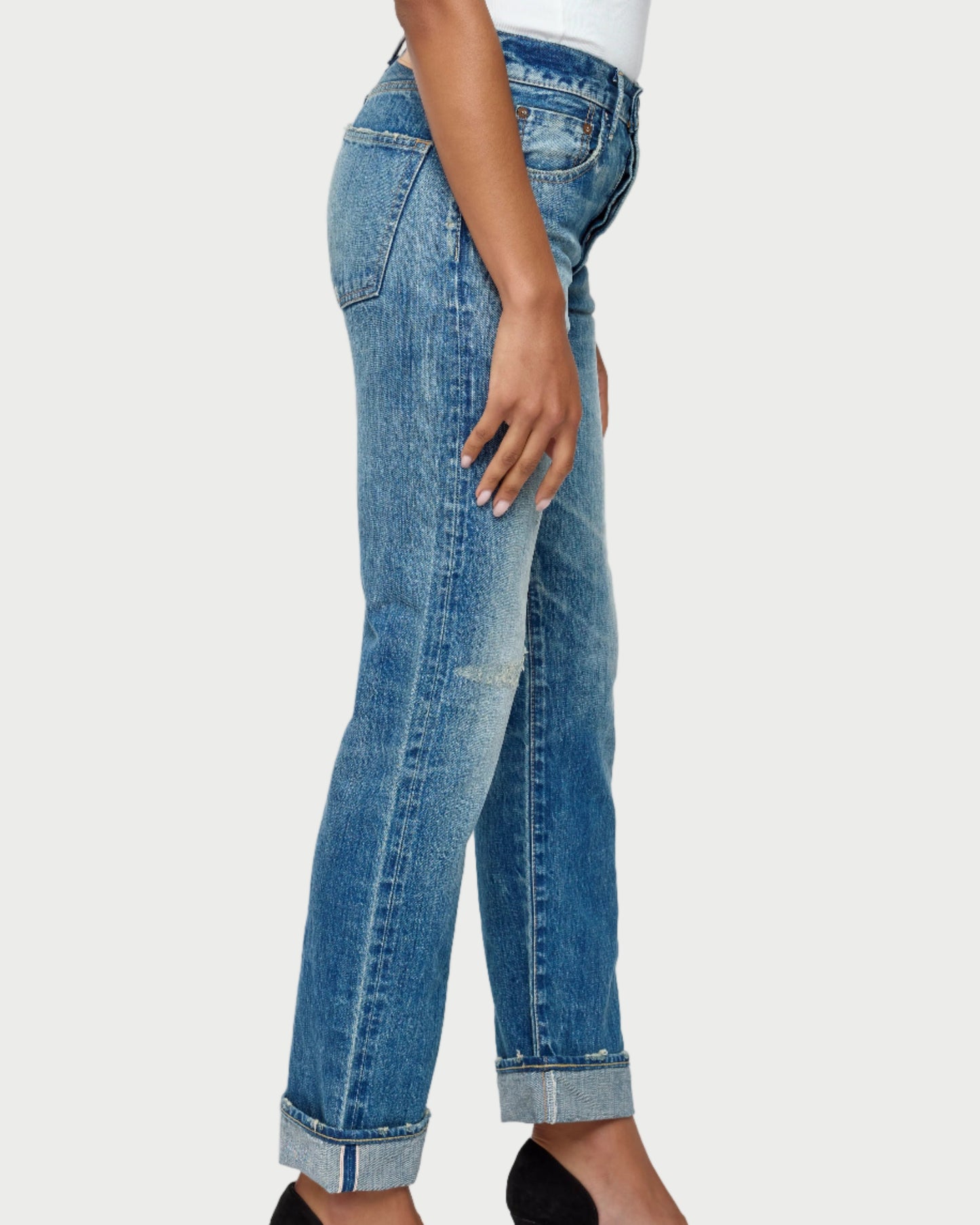 Person wearing blue jeans with a white background