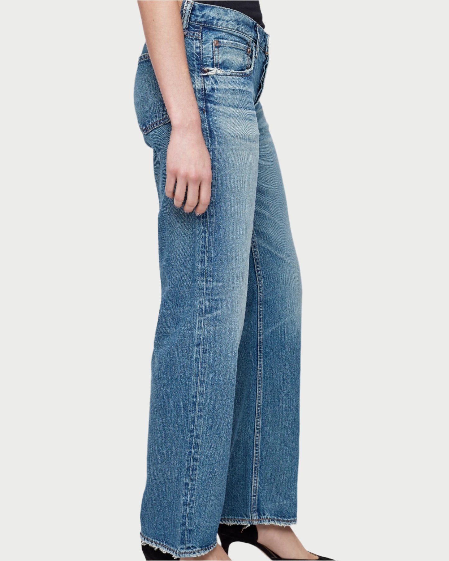 A person wearing light blue Moussy Millsboro Straight Low Jeans made from Japanese cotton denim with frayed hems and black shoes, shown from the hip down against a plain background.