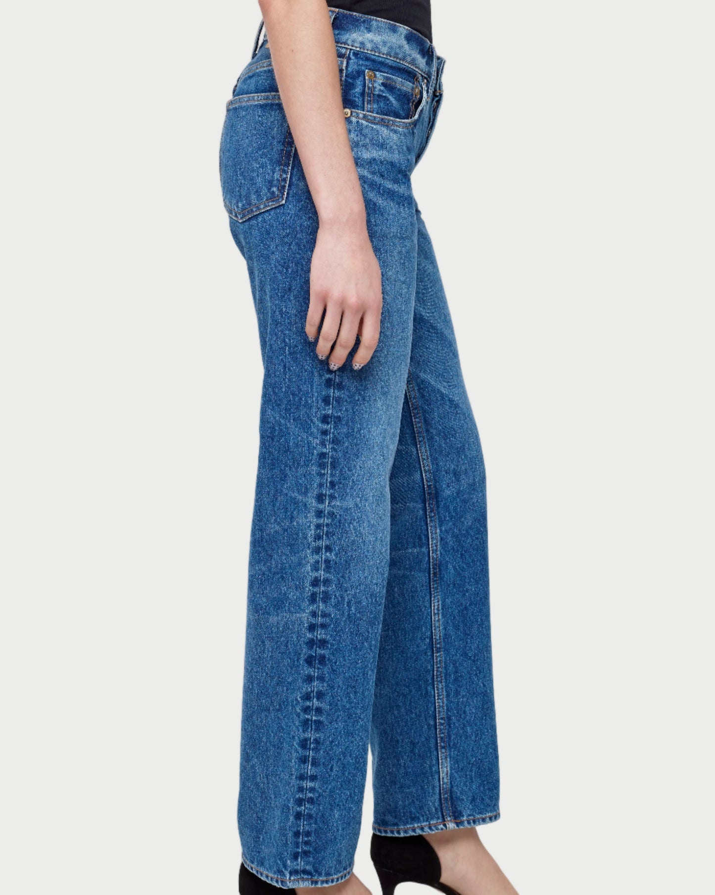 Blue jeans worn by a person on a white background