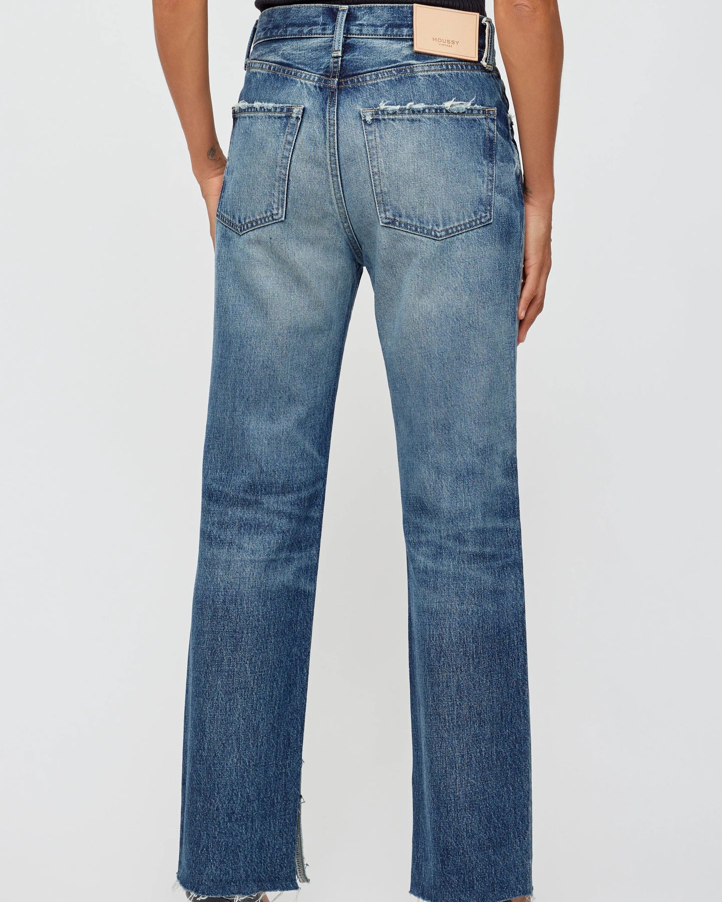 Blue jeans worn by a person on a white background