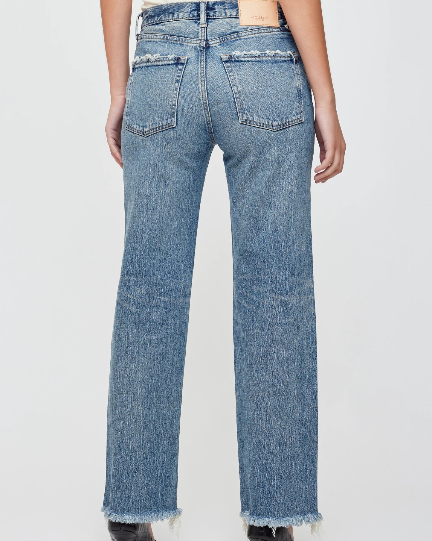 Blue jeans worn by a person on a white background
