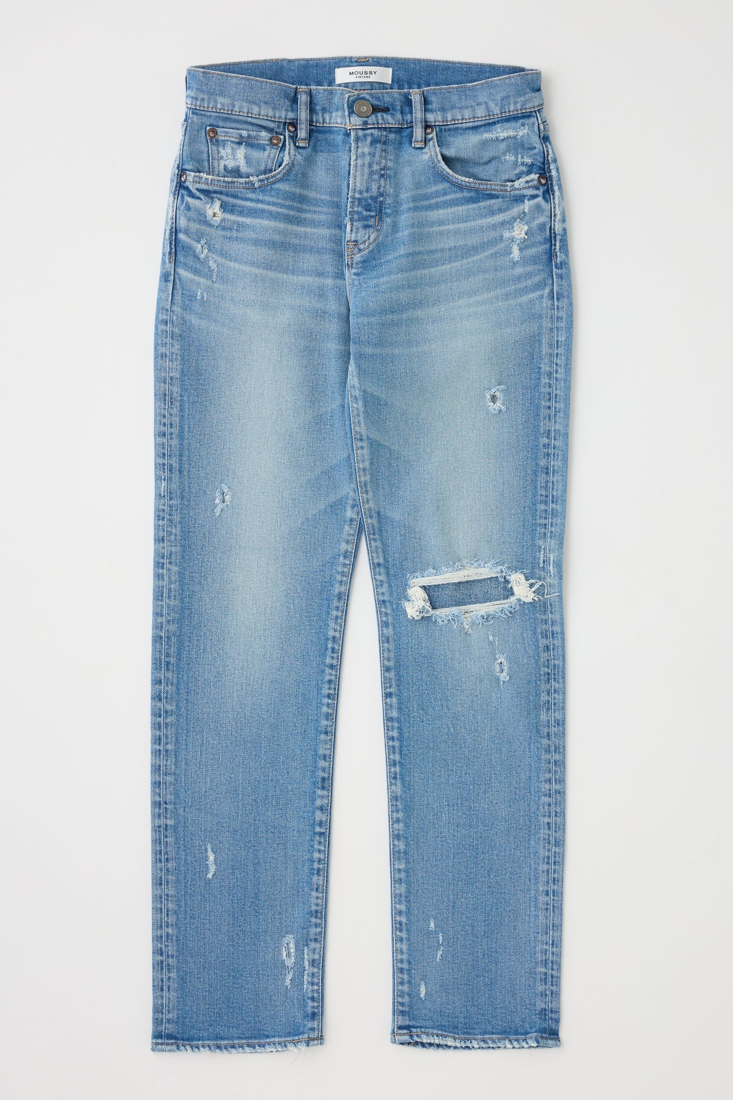 Blue jeans with slight distressing on a light gray background