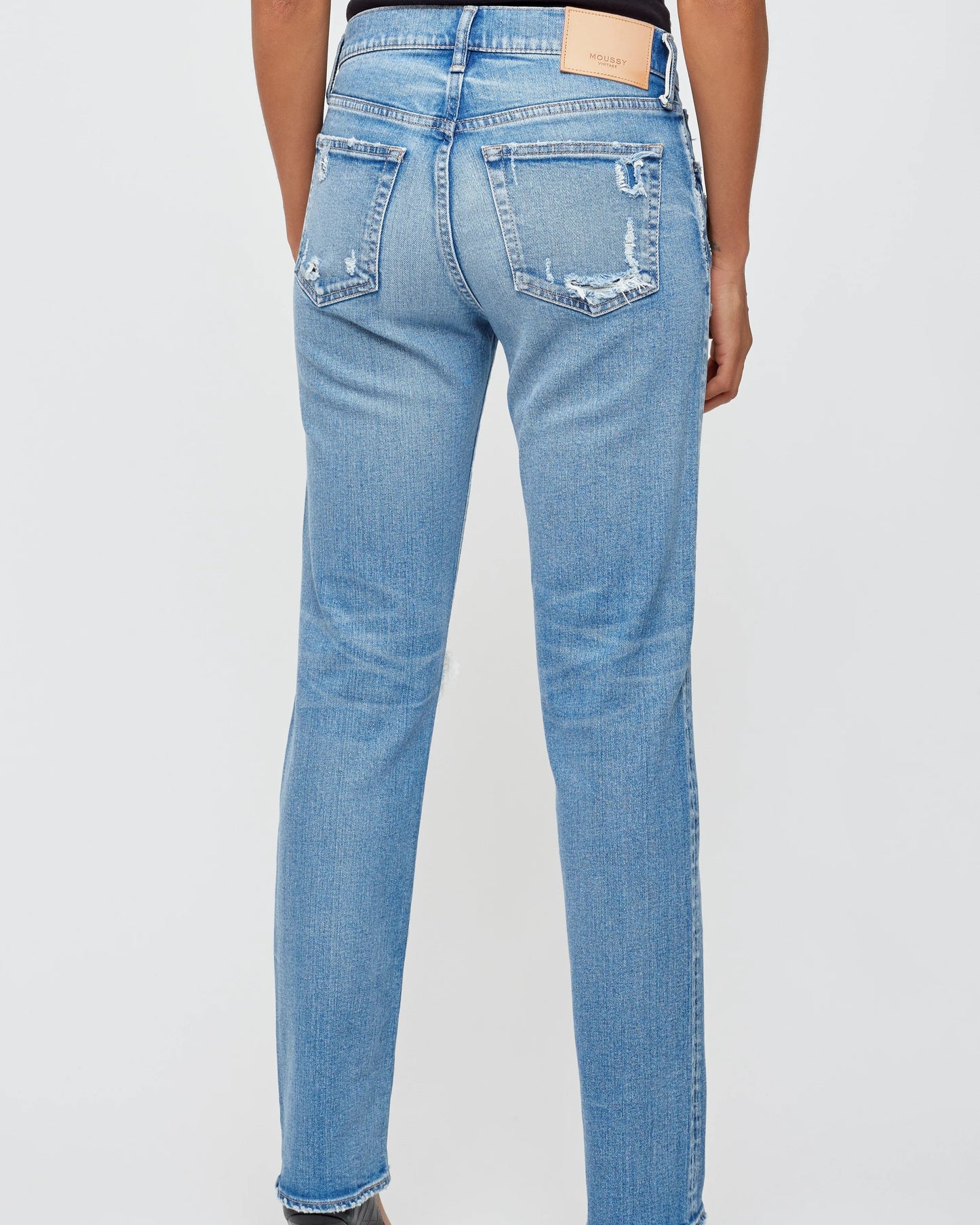 Light blue jeans worn by a person on a light gray background