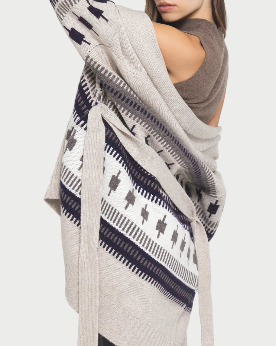 Woman wearing a patterned cardigan with a plain background