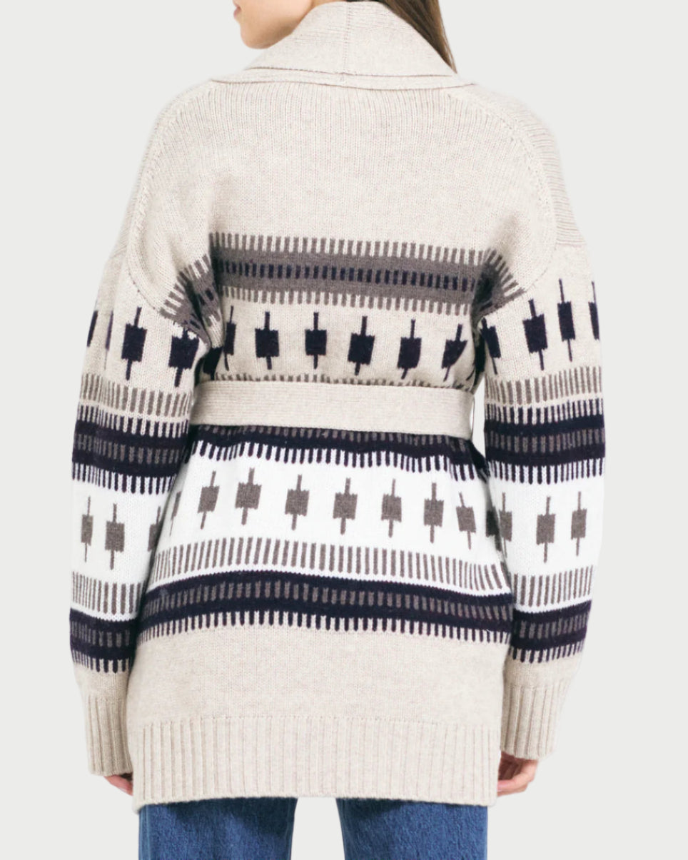Person wearing a patterned cardigan with a white background
