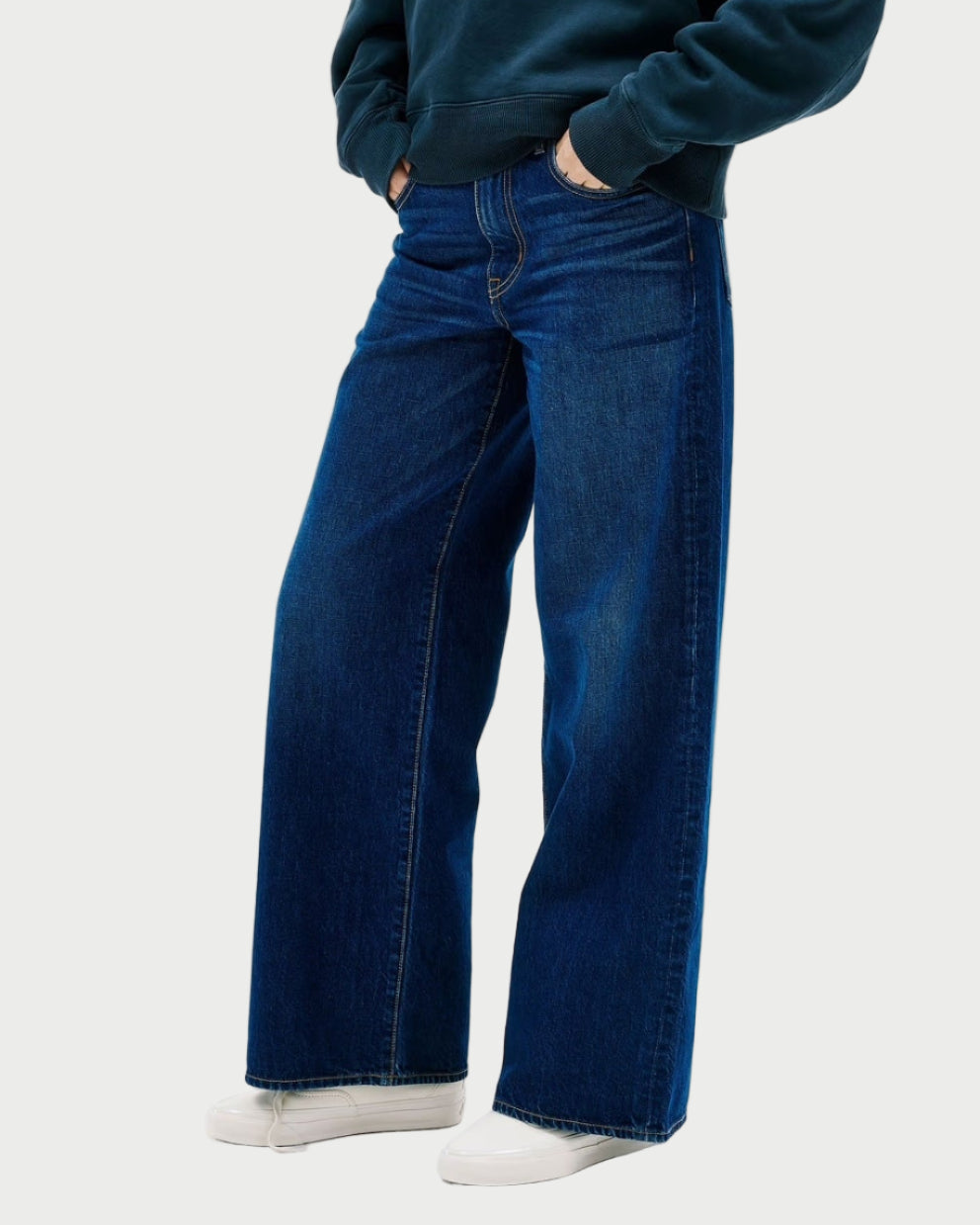 Person wearing a blue hoodie and jeans on a white background