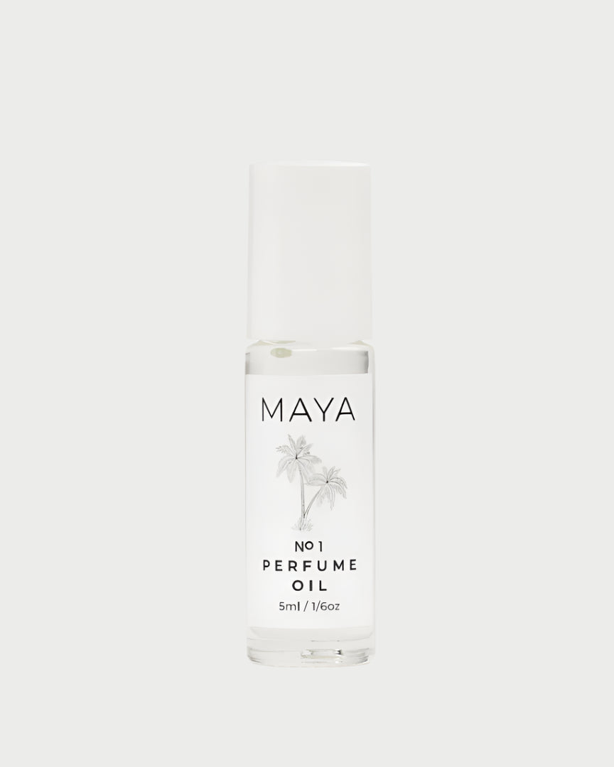 A clear glass bottle of MAYA’s Maya No.1 Mini 5ML Perfume Oil features a white cap, minimalist label, and palm tree graphics, evoking an exotic escape and emphasizing sustainability—all set against a light backdrop.