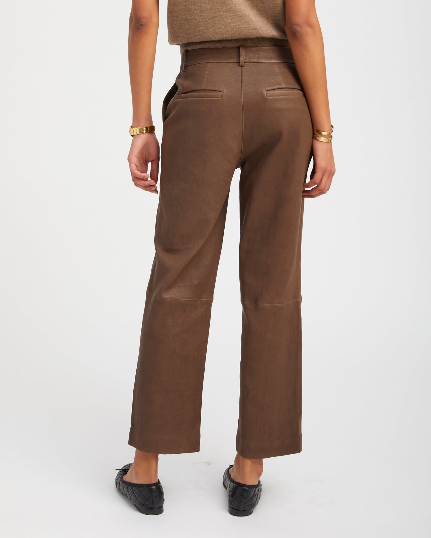 Person wearing a brown outfit on a white background