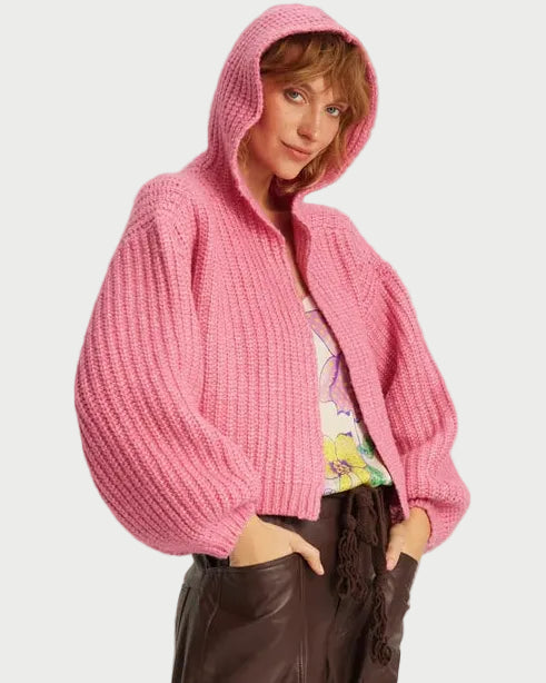 A person wearing a fuchsia ME369 Romi Hoodie, a chunky ribbed knit piece featuring a zip-up front and voluminous sleeves.