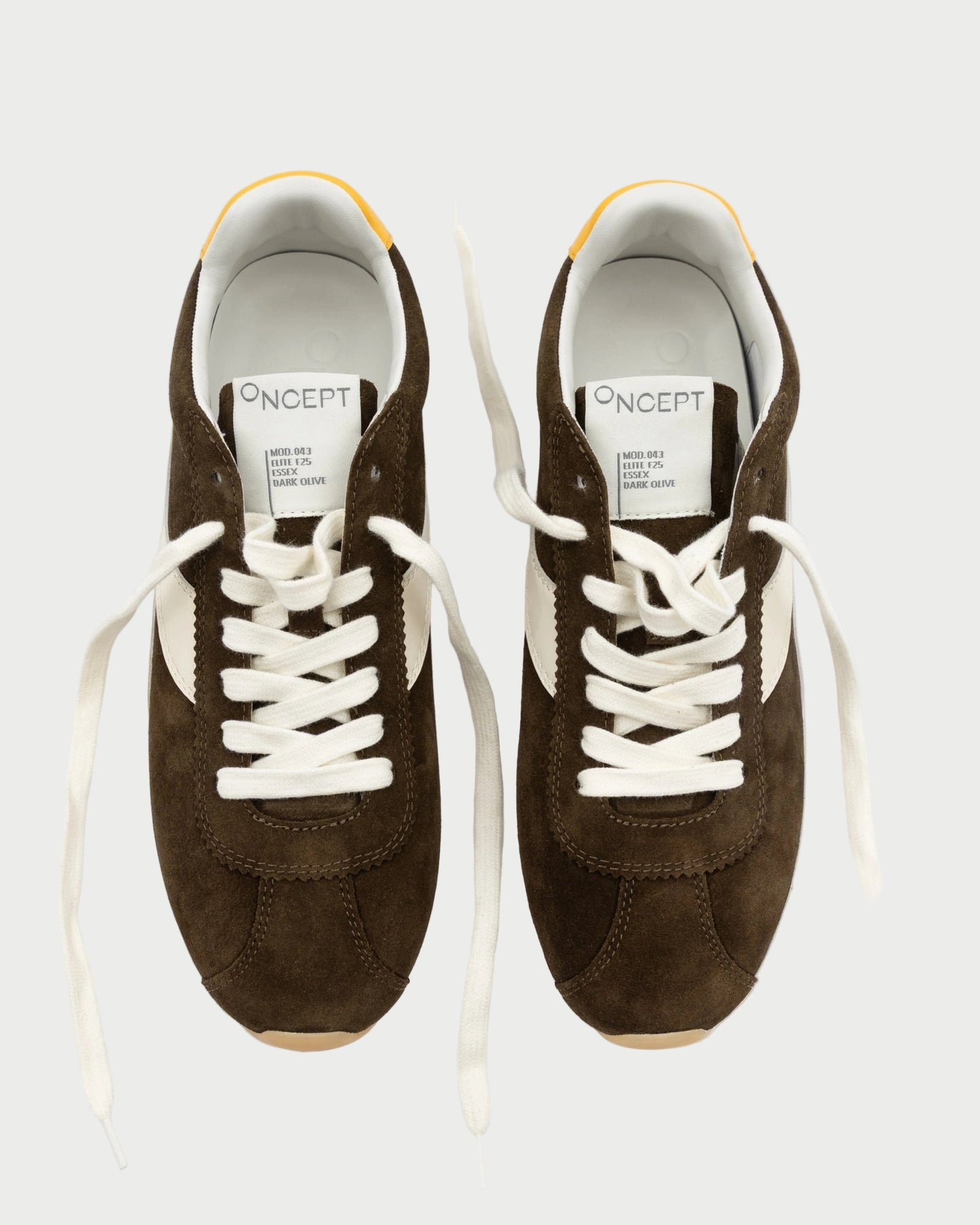 Pair of brown sneakers with white laces on a white background