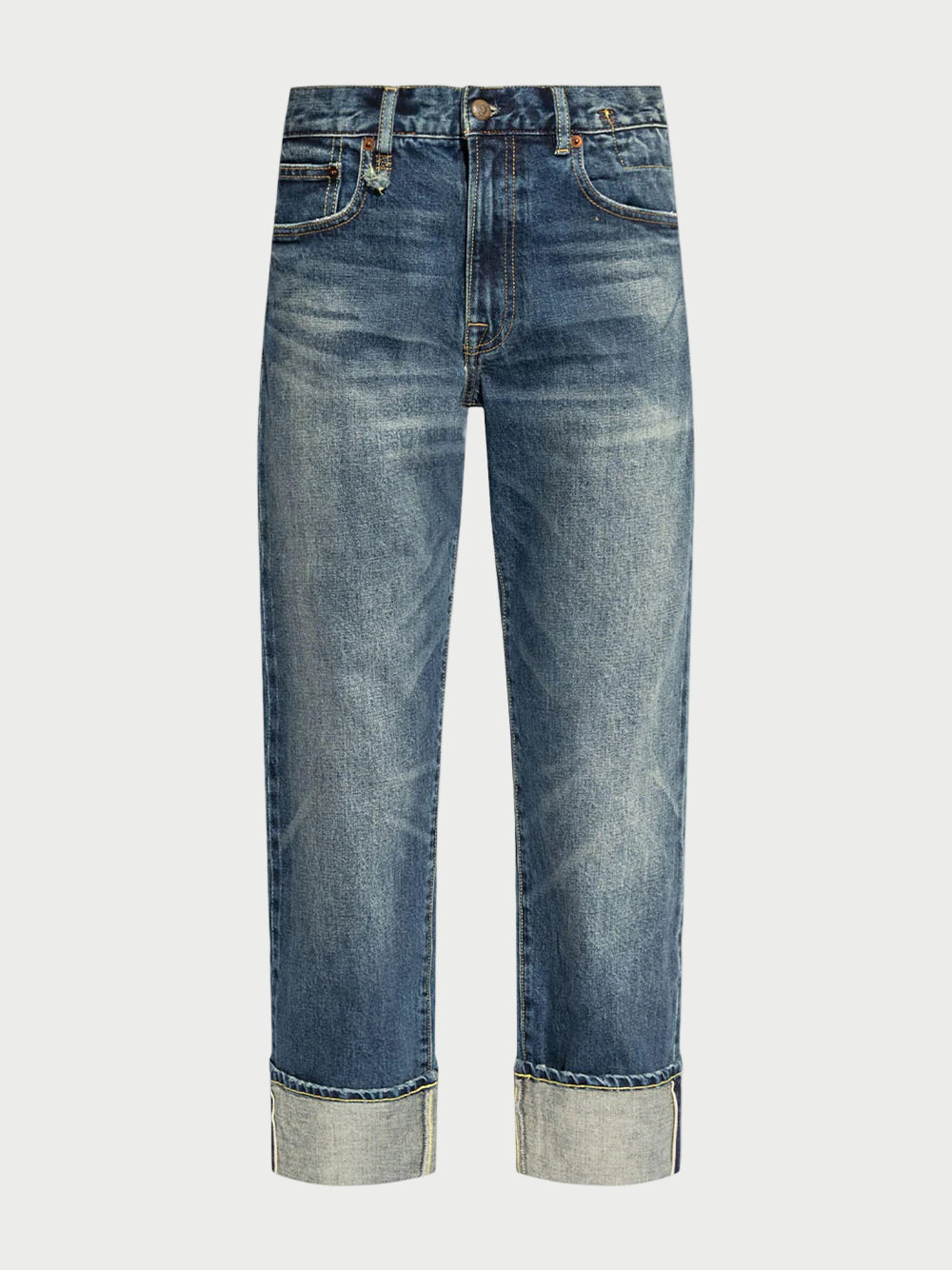 The R13 Cuffed Romeo Jean Merrin Blue features a slim boyfriend fit in Italian selvedge denim with a faded wash, straight legs, wide rolled cuffs, classic five-pocket style, and distinctive yellow stitching.