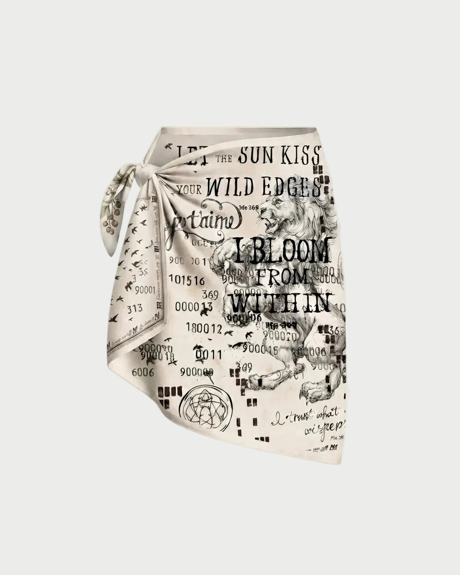 A square scarf with a black and white graphic print featuring text, numbers, and vintage-style illustrations, tied in a knot on a light beige background.