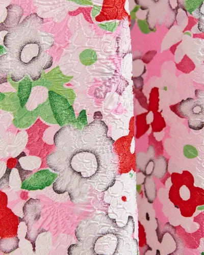 Close-up of floral fabric with pink, red, and green colors.
