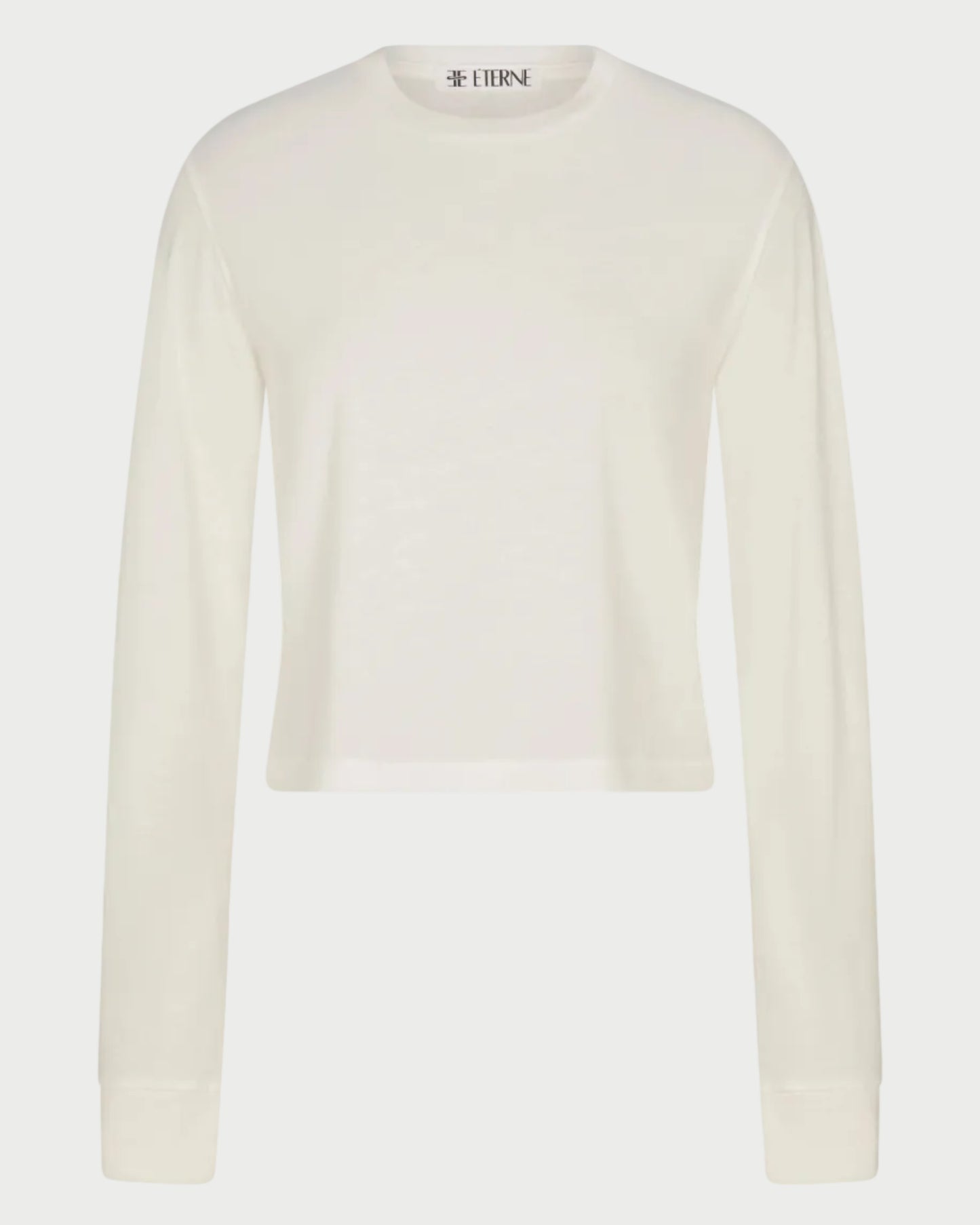 The Éterne Long Sleeve Boxy Tee by Eterne features a relaxed, boxy fit and is crafted from a soft cotton-modal blend. Shown here in plain white against a white background.