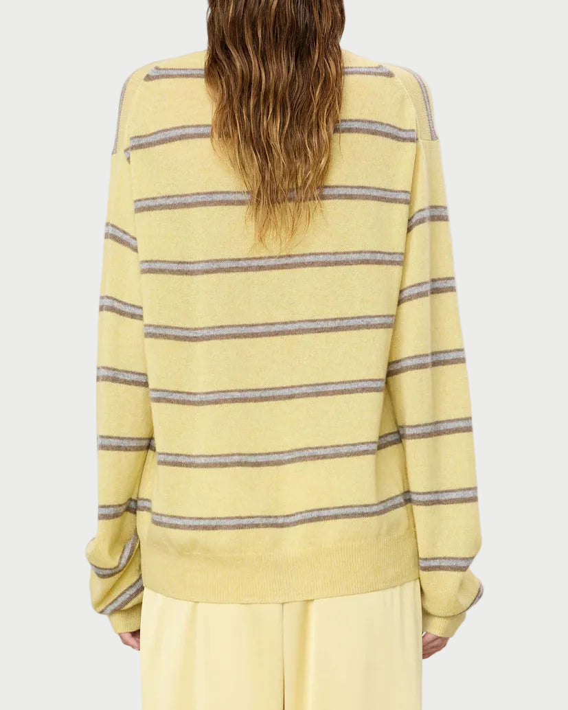 Person wearing a yellow striped sweater on a plain background