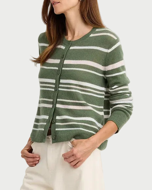 A woman modeling a green and white striped knit cardigan with a front zipper, paired with cream wide-leg trousers and dark brown sandals, against a plain white studio background.