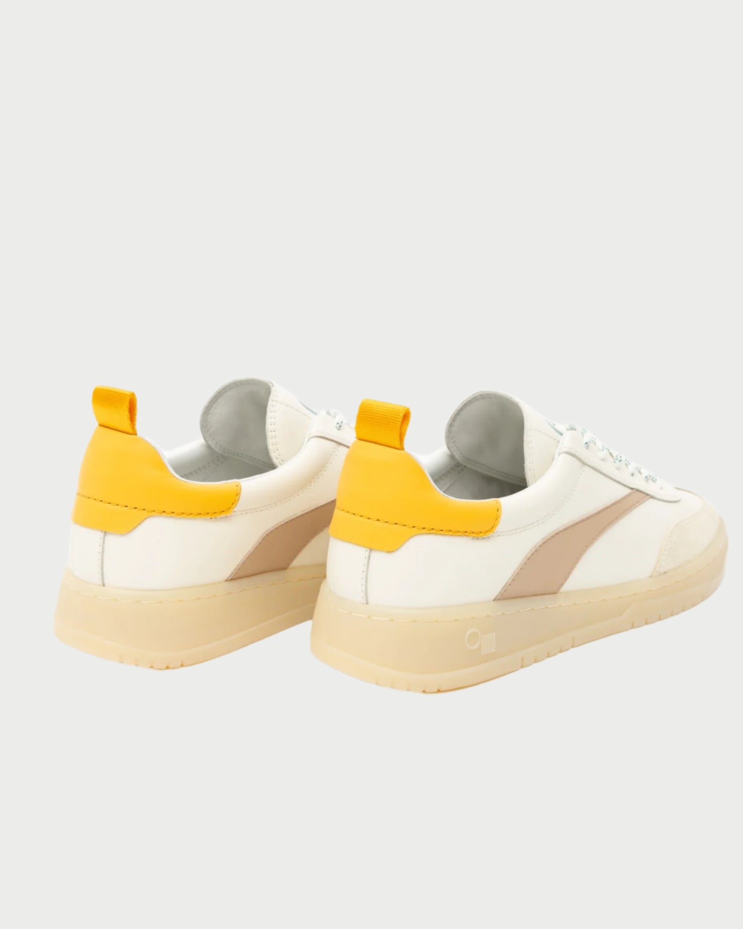 A pair of Oncept Panama Sneakers featuring white uppers, beige accents on the sides, yellow heel tabs, light beige soles, and white laces. The view is angled from the back on a plain light background.