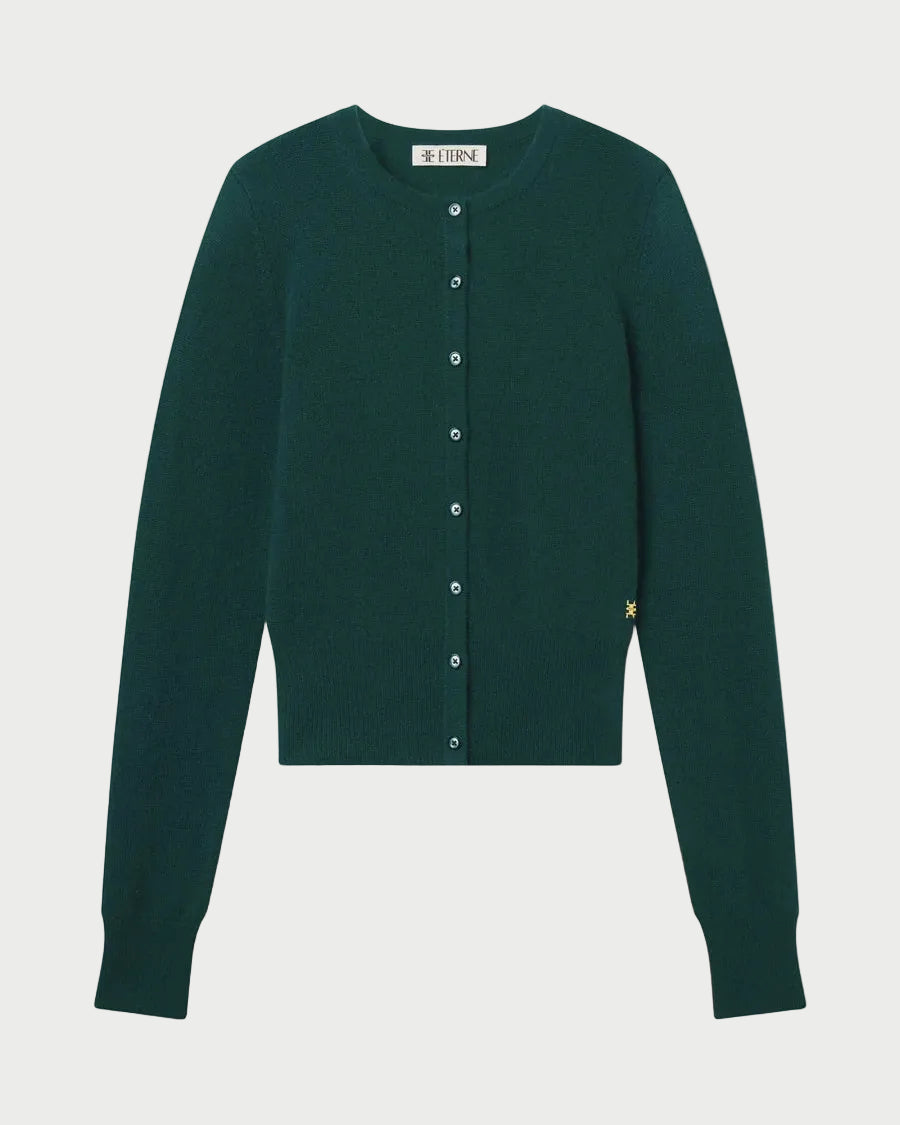The Eterne Éterne Reese Cashmere Sweater is a dark green, long-sleeve, button-up cardigan with a round neckline and ribbed cuffs and hem. Designed with a slim fit for a sleek look, the sweater is displayed against a white background.