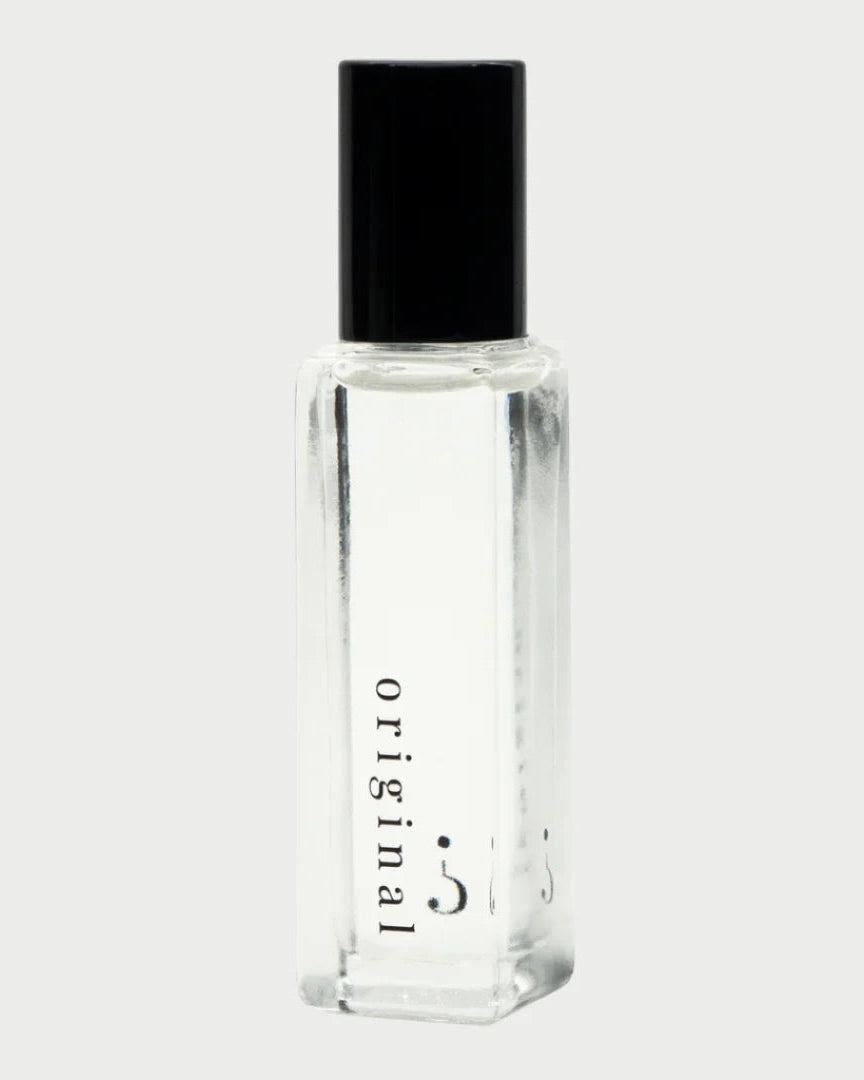 The Riddle Roll-On Oil in Original 20ml by Riddle Oil features a clear glass bottle with a black cap, labeled "original" in lowercase letters on the side. Celebrated for its natural scent and understated charm, this sleek and sophisticated bottle has developed a devoted fan base. It sits against a plain, light background.