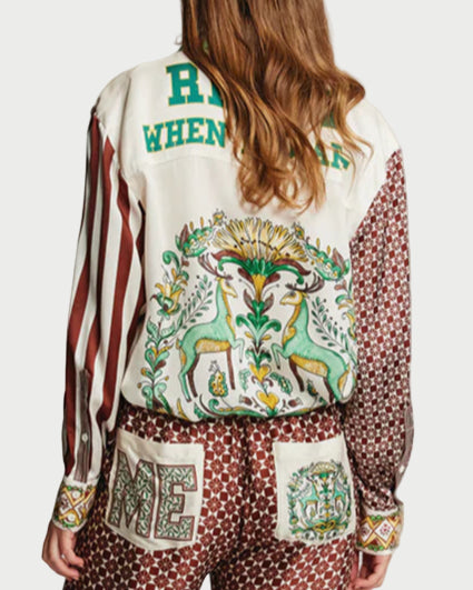 Person wearing a patterned jacket and pants on a plain background