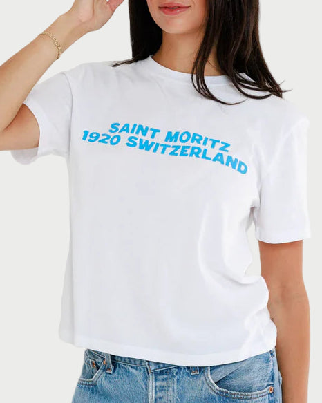 Woman wearing a white t-shirt with blue text and blue jeans against a white background