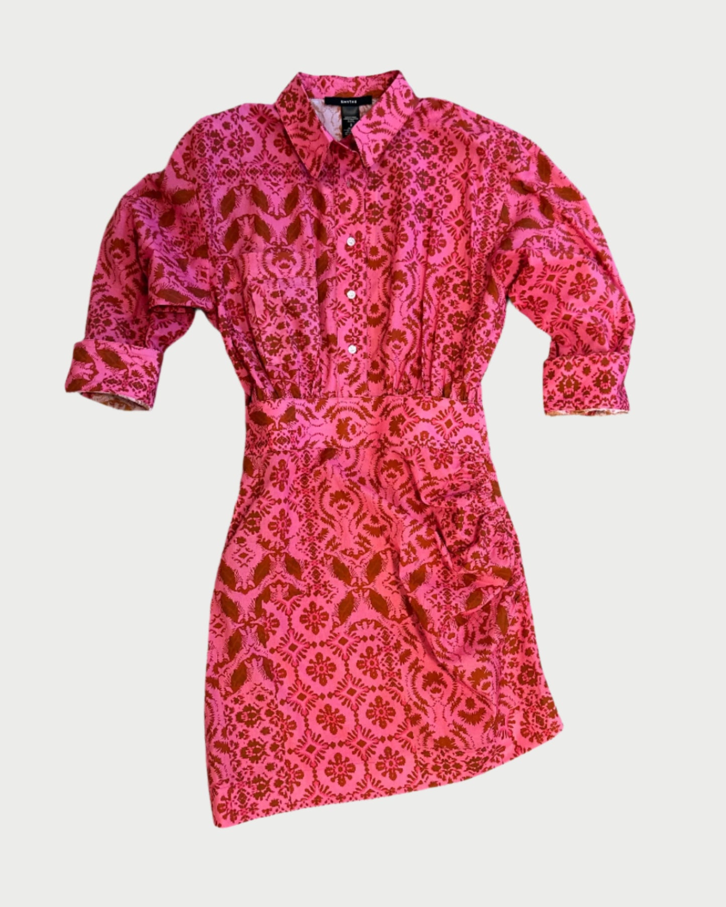 The Smythe Mini Shirt Dress features long sleeves, a button-up front, a collared neckline, a pink and red floral print, and a matching fabric belt at the waist.