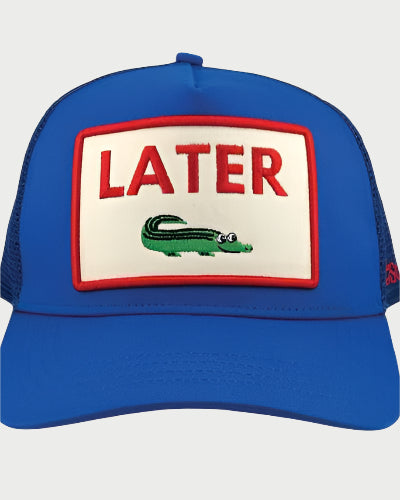 The Soulbyrd Later Gator Trucker Hat features a blue front, breathable mesh back, and a white patch with "LATER" in bold red letters above a small green cartoon alligator. Brand: Soulbyrd.