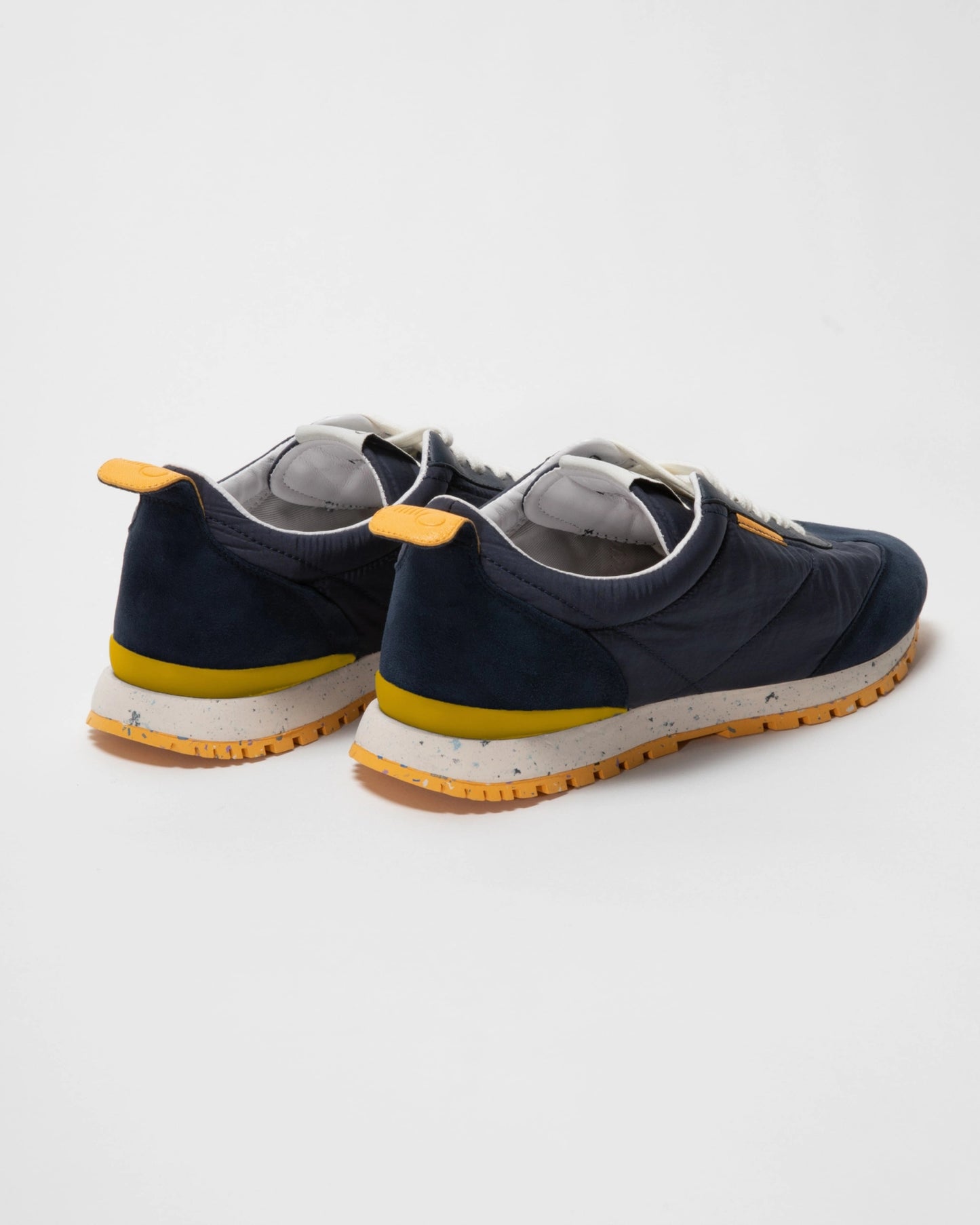 Navy sneakers with yellow accents on a white background