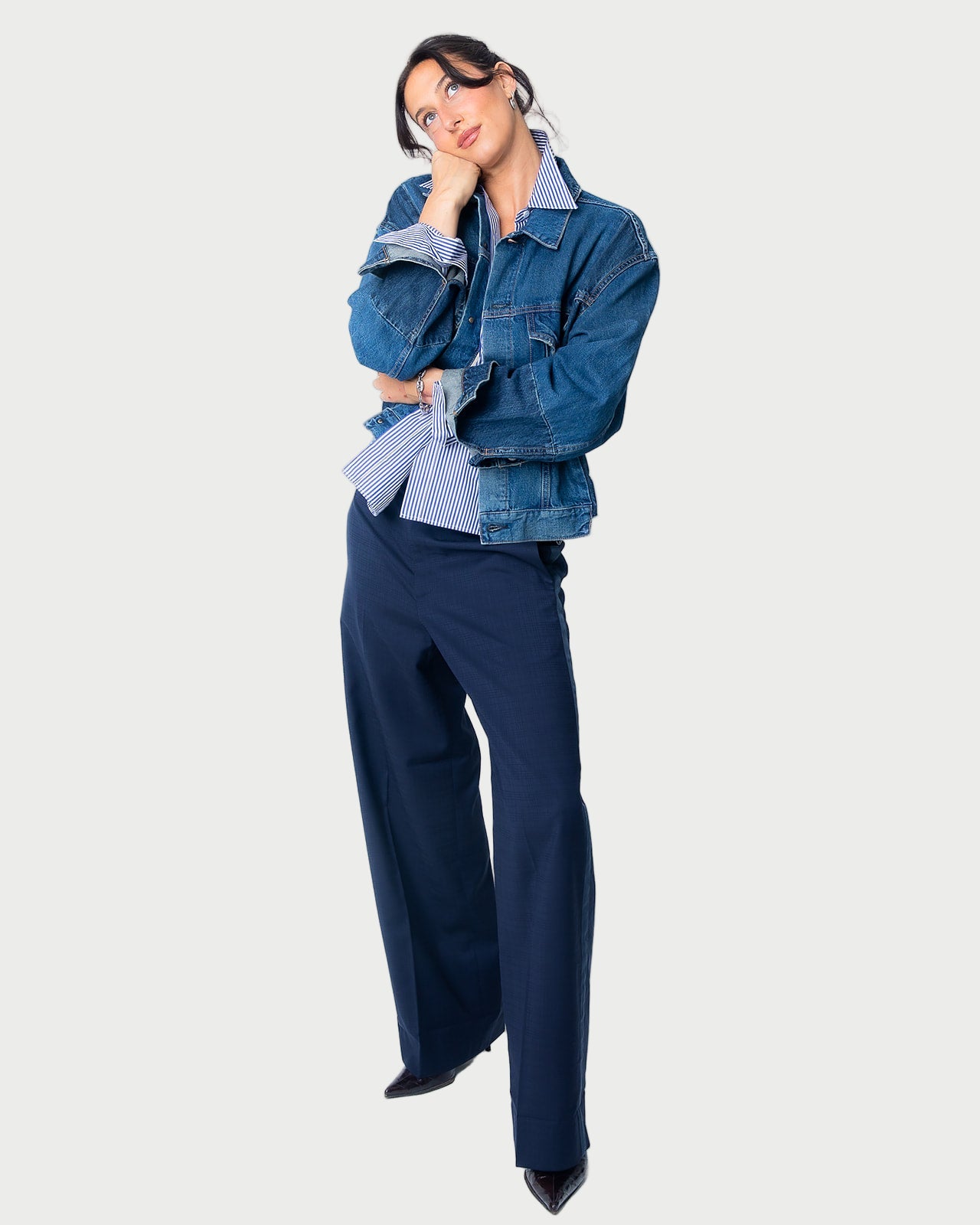 A woman poses in the Moussy Dover Two Tone Jean Jacket over a blue-striped shirt and wide-leg navy pants with black pointed shoes, set against a plain light background.