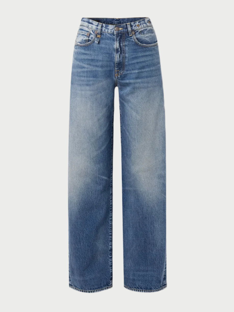 The R13 D'arcy Jeans by R13 are vintage-inspired, high-waisted wide-leg blue jeans with a faded wash and classic five-pocket design, shown against a white background.