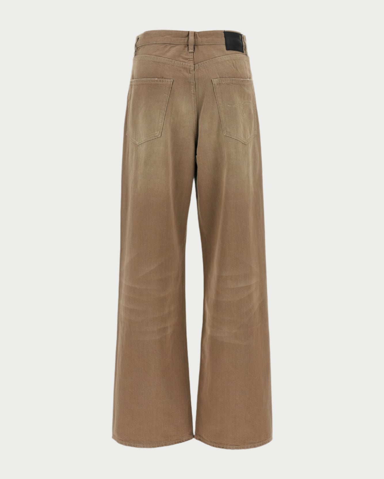 The Damon Pleated Jeans in Sawdust by R13 are shown from the back with a wide-leg, oversized slouchy fit, two rear pockets, belt loop waistband, and a small black patch on the right side of the waistband.