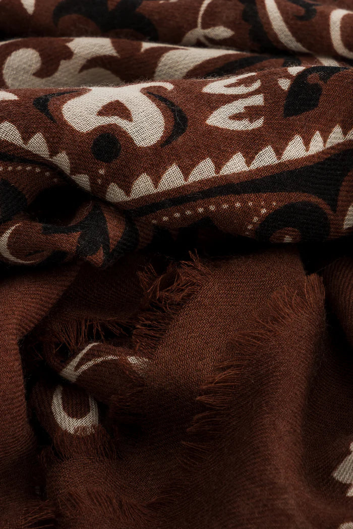 Close-up of the Maison Lecomte Flament Bandana Scarf by Maison Lecomte Flament, showcasing chocolate, beige, and black abstract patterns with a soft textured surface and frayed edges.