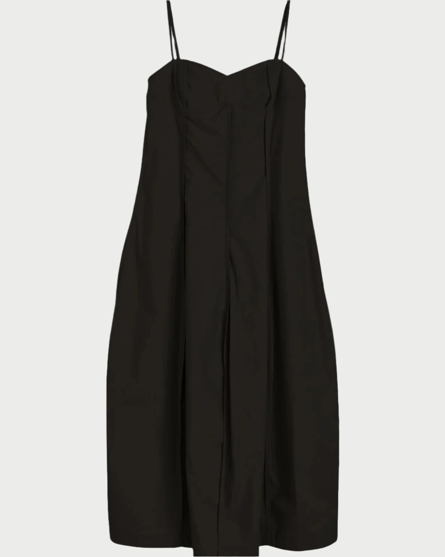The Herskind Luca Dress is a black midi dress with thin spaghetti straps, a fitted bodice, tailored silhouette, and a subtle front center seam for understated elegance.