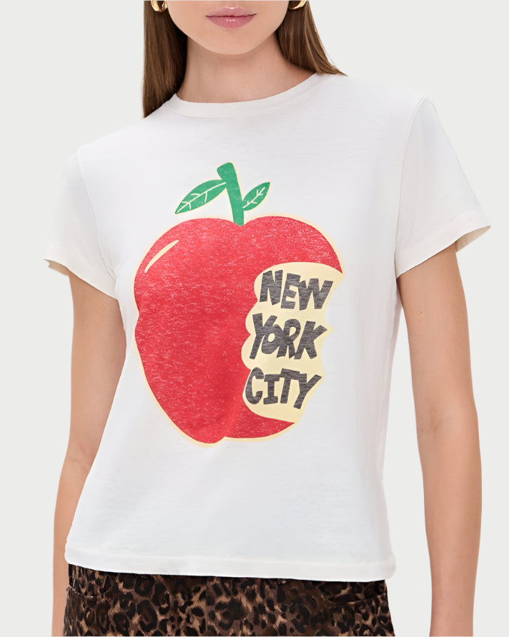 Woman wearing a white t-shirt with a red apple graphic and 'New York City' text, paired with a leopard print skirt.