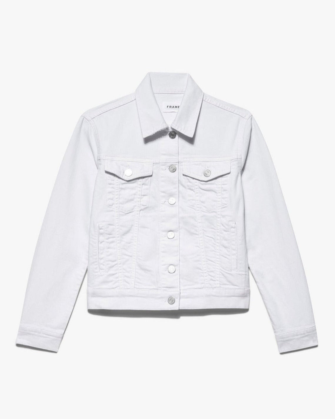 A Frame Le Vintage Denim Jacket in White with long sleeves and a collar. It features a button-down closure with silver buttons and two buttoned flap chest pockets. This summer white staple is simple and classic, perfect for any wardrobe.