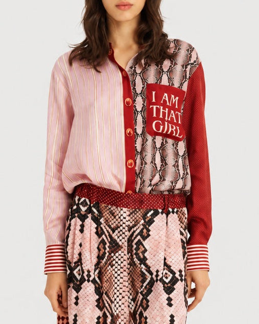 The ME369 Isabel Shirt Red Aura is a long-sleeved button-down featuring a mix of pink stripes, snakeskin print, and red textures, with a chest pocket that reads “I AM THAT GIRL.”