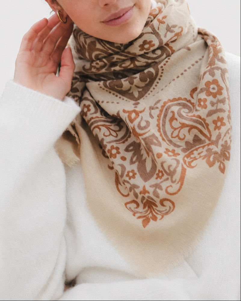 Maison Lecomte Flament Cashew bandana scarf worn with a cream sweater.