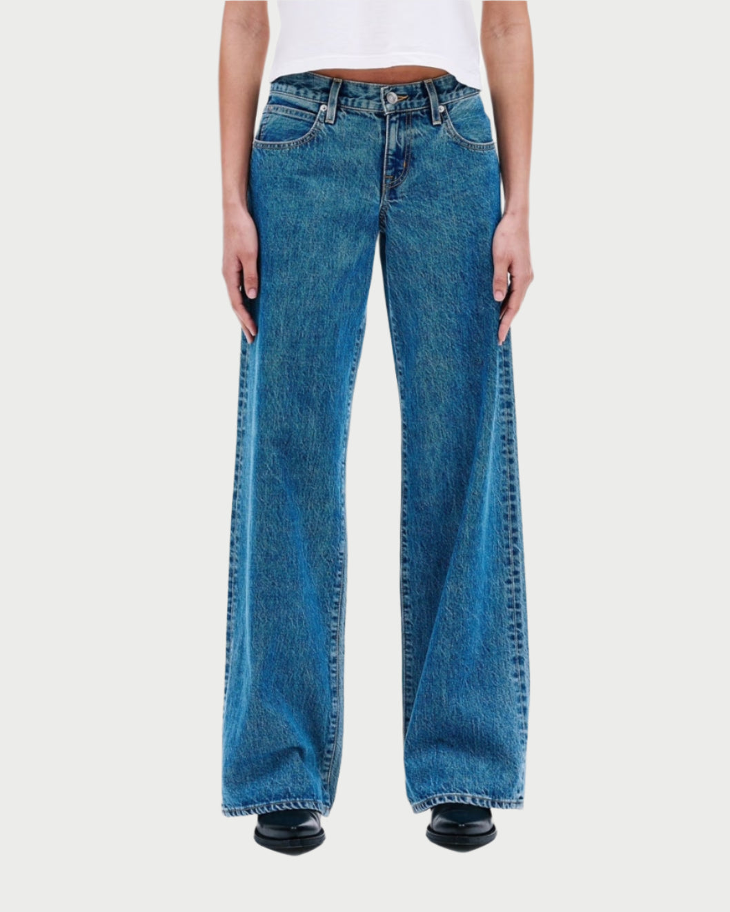 Blue jeans worn by a person on a white background